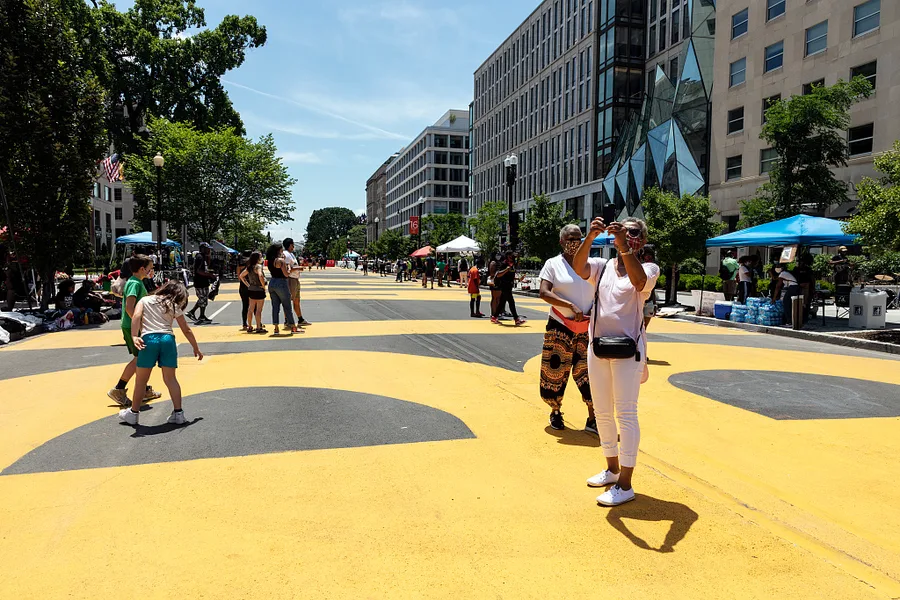 The Black Lives Matter Movement / Contemporary Civil Rights — People walking on the Black Lives Matter large mural painted on Black Lives Matter Plaza